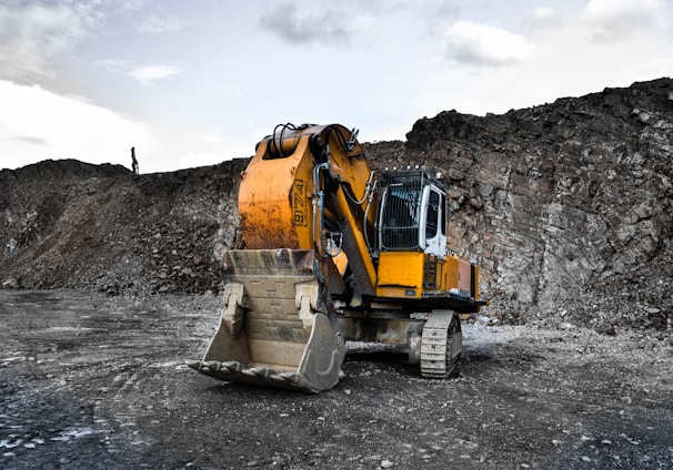 yellow and black excavator near hill