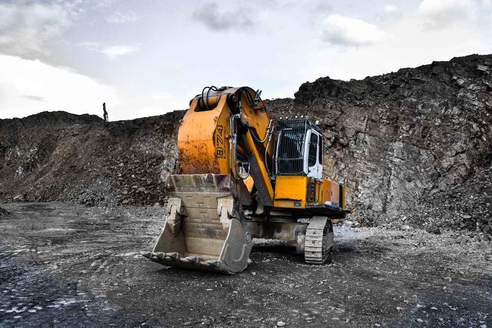 yellow and black excavator near hill