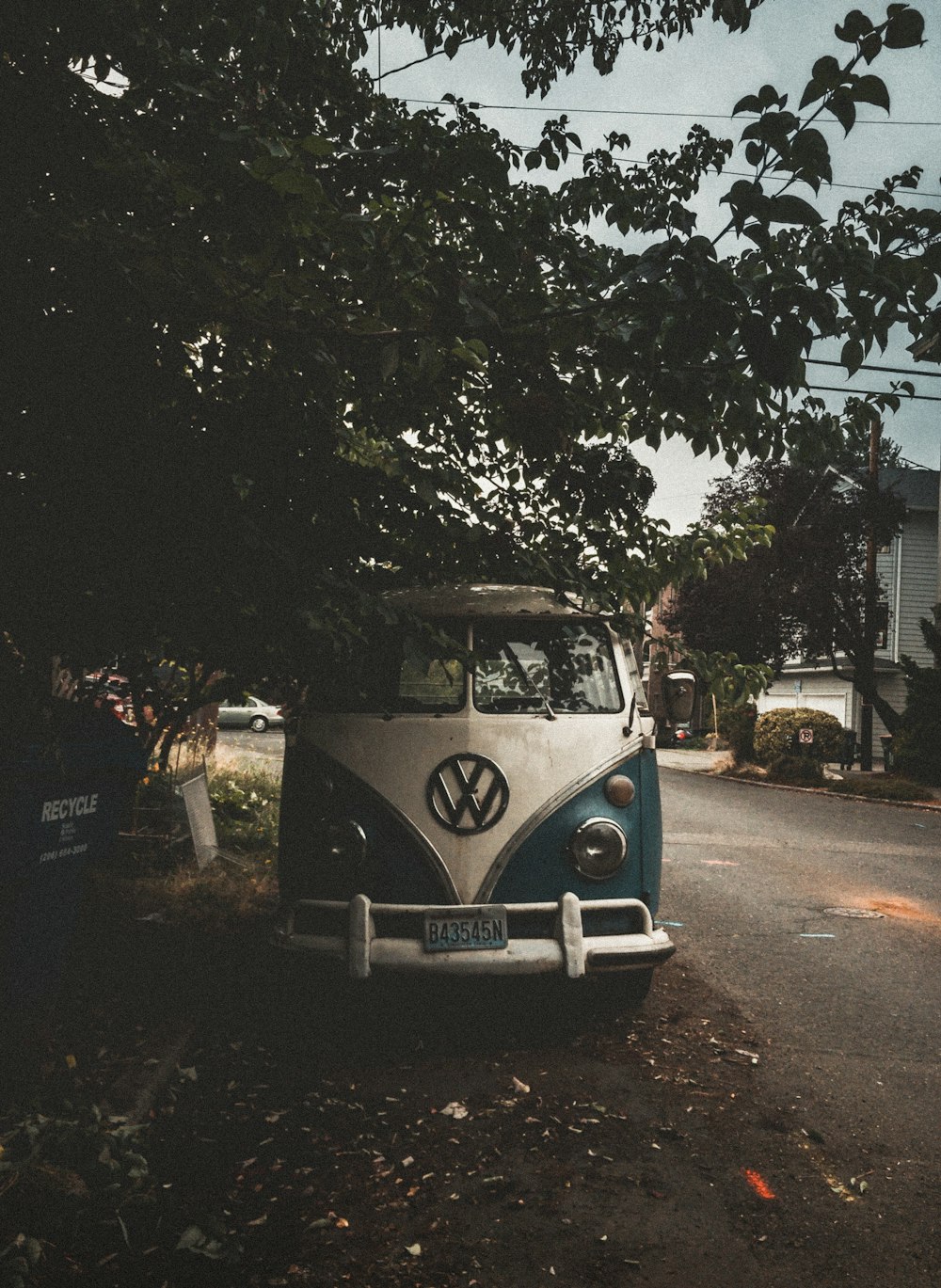 white and blue Volkswagen van park beside road