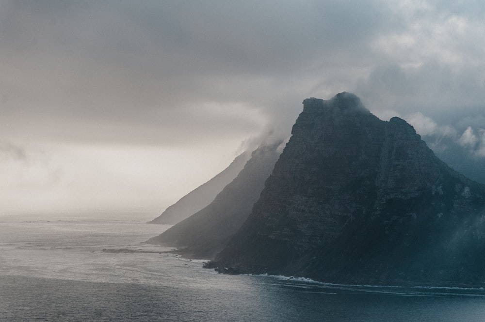 aerial photography of rock mountain island with ocean water view during daytime