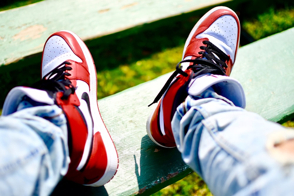 person wearing red-and-white Nike Air Jordan 1 shoes