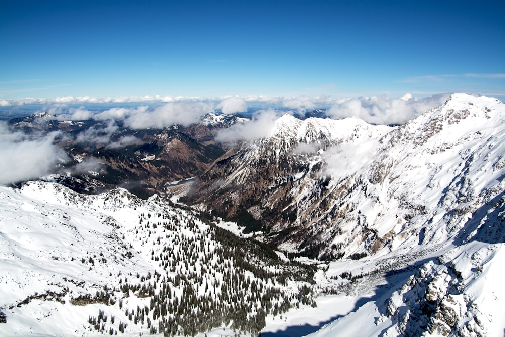 Luftaufnahme von schneebedeckten Bergen unter bewölktem Himmel