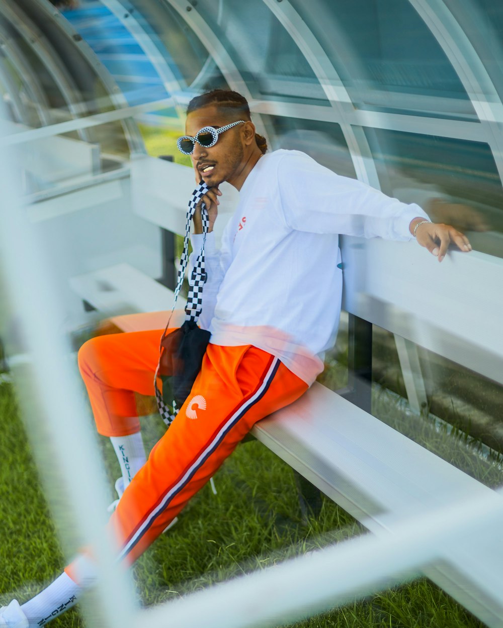 a man sitting on a bench wearing sunglasses