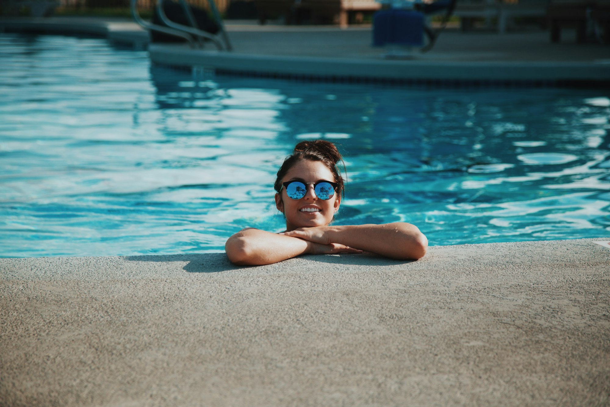 foto de menina na piscina usando óculos de sol