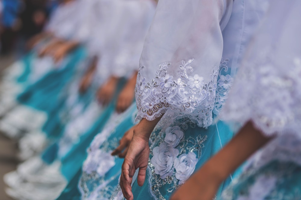 women wearing white-and-teal floral dresses