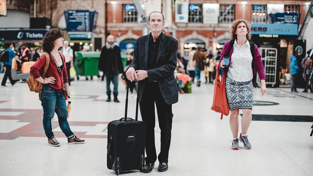 standing man holding it's luggage bag