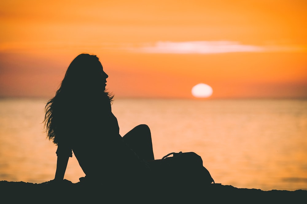 Foto de la silueta de la mujer en la puesta del sol