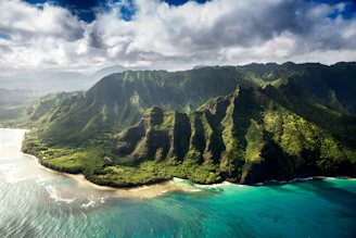 An aerial view of the lush green Na Pali Coast mountains in Kauai, Hawaii