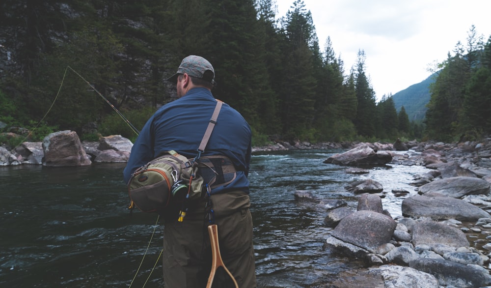 man fishing on river at daytime