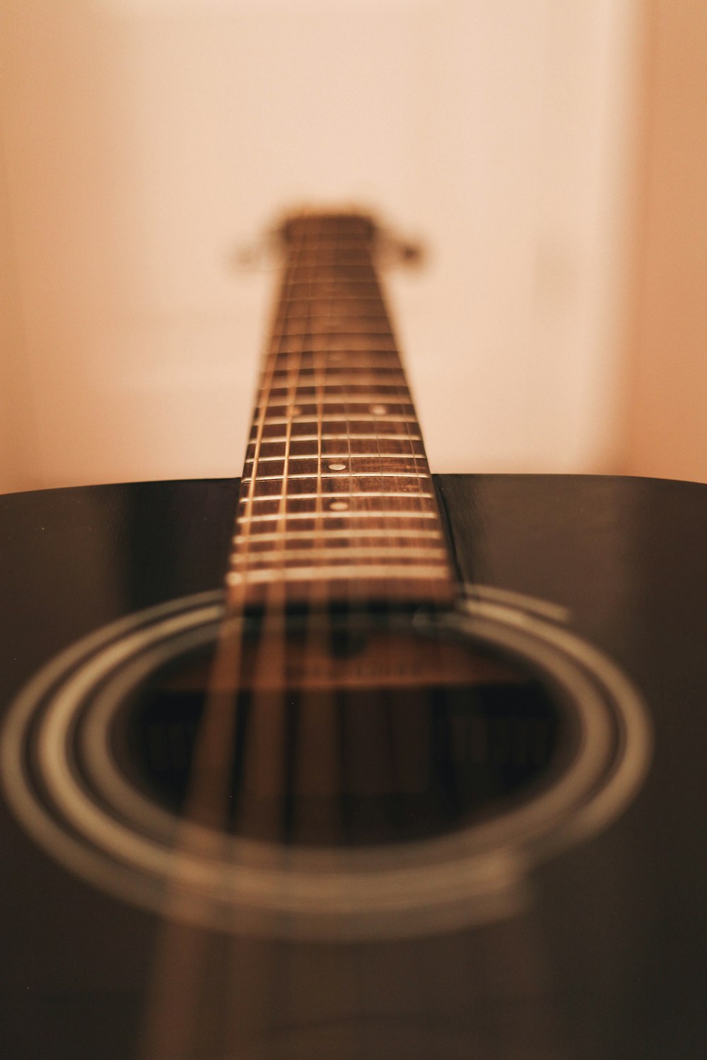 close-up photograph of black dreadnought acoustic guitar