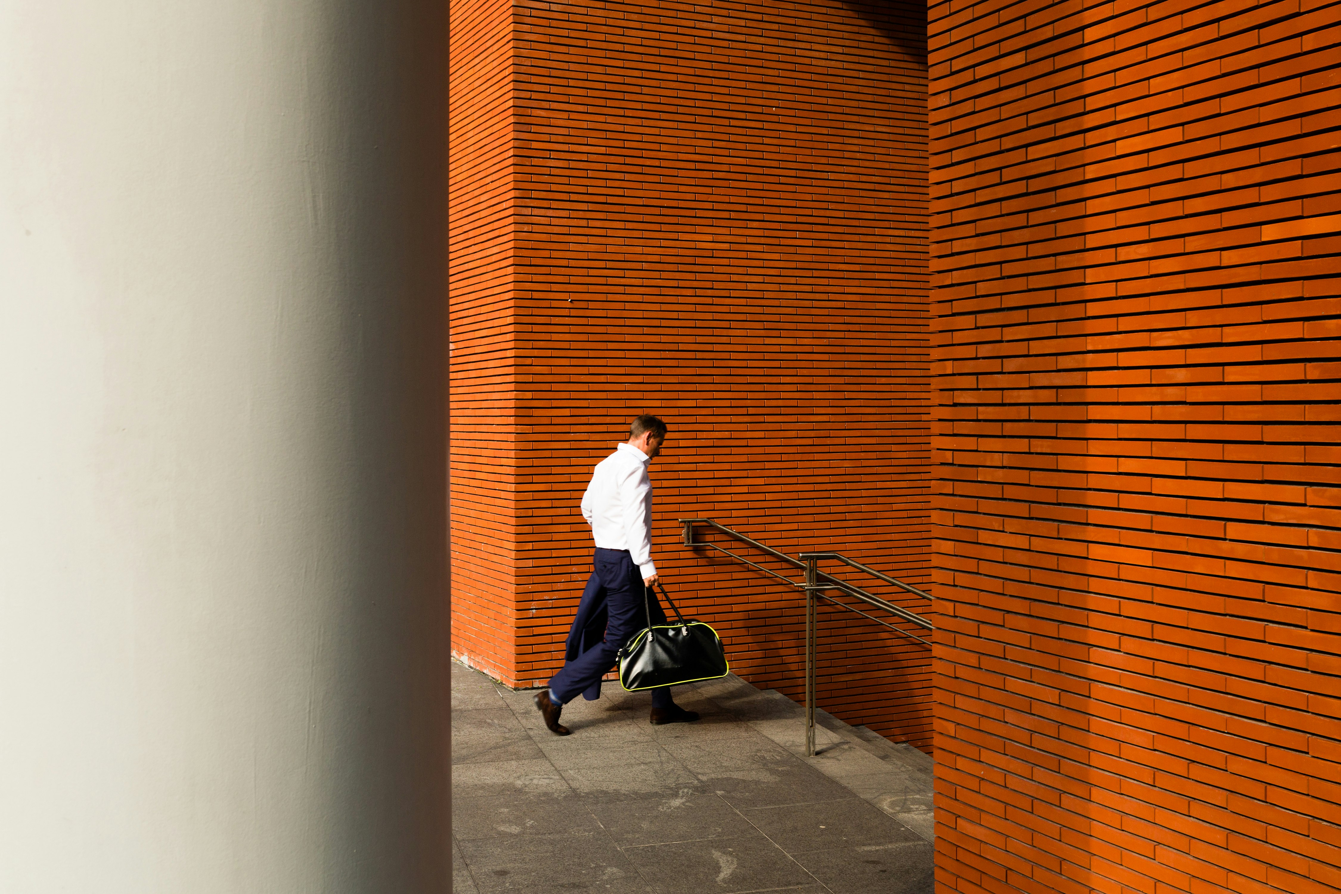 man holding duffel bag down stair