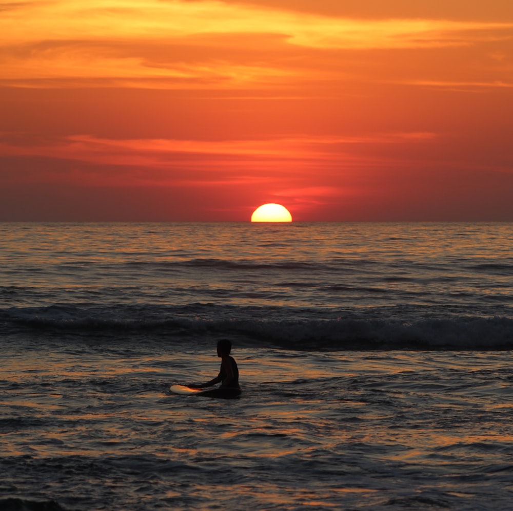 man on body of water during sunset