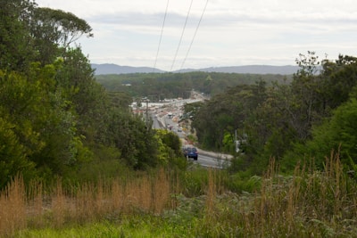 An aerial view of a newly constructed highway cutting through green hills.