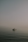 A small fishing boat floating on calm waters of West Fox Lake early in the morning.