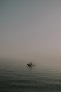A serene fishing scene at dawn with a small boat floating on calm waters near Belitung.