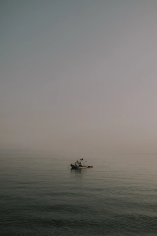A serene fishing scene at dawn with a small boat floating on calm waters near Belitung.