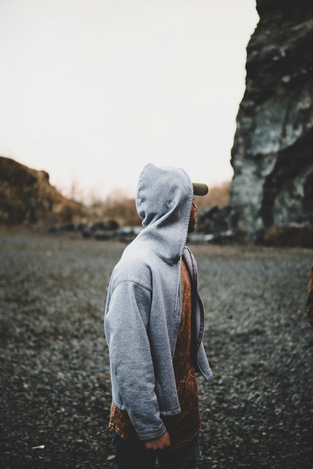 selective focus photography of man standing near rock formation