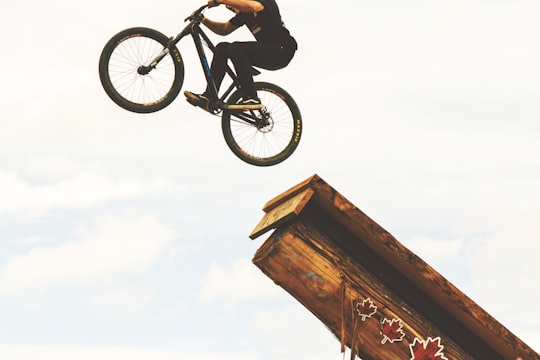 man riding on BMX bike on mid air during daytime in Whistler Canada