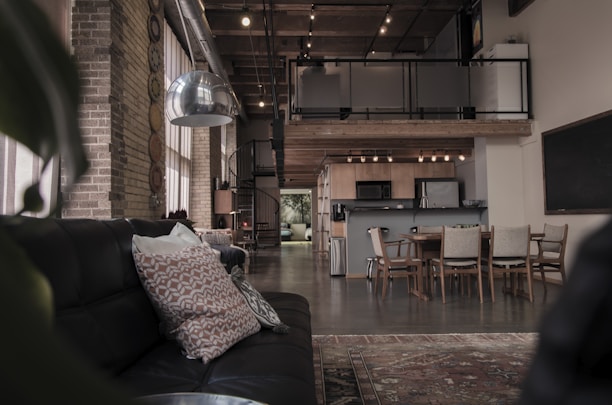 A spacious urban loft with exposed brick walls and large industrial windows.