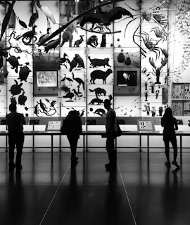 Visitors quietly observing a large canvas depicting endangered species at the artewild exhibition.