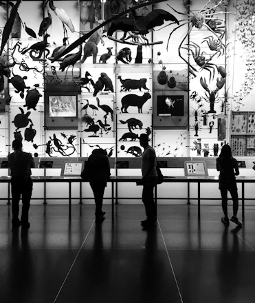Visitors quietly observing a large canvas depicting endangered species at the artewild exhibition.
