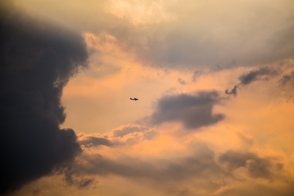 plane flying under clouds