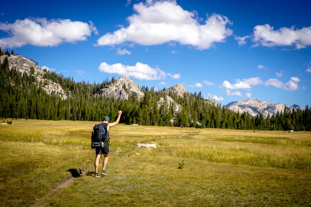 man walking on grass field during daytime