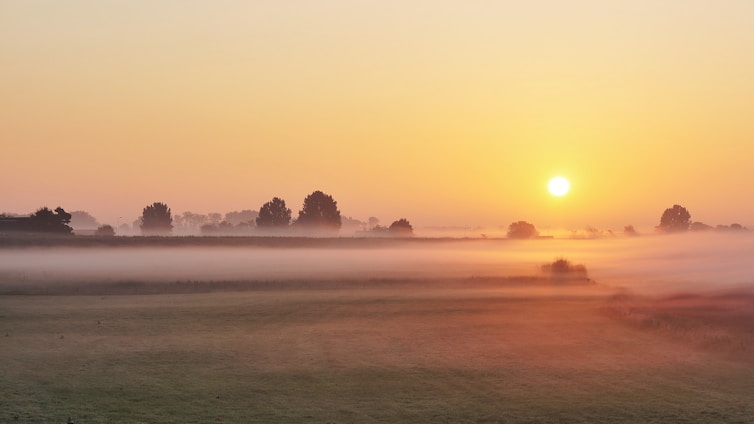 A calm sunrise over a misty landscape symbolizing clarity and new beginnings.