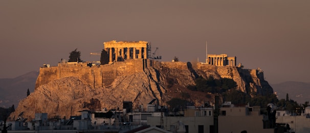 An aerial shot of an ancient temple complex bathed in warm golden light.