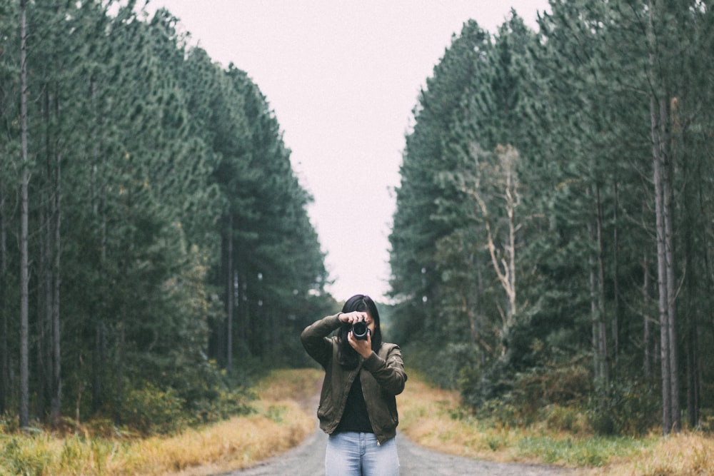 woman standing on road taking photo