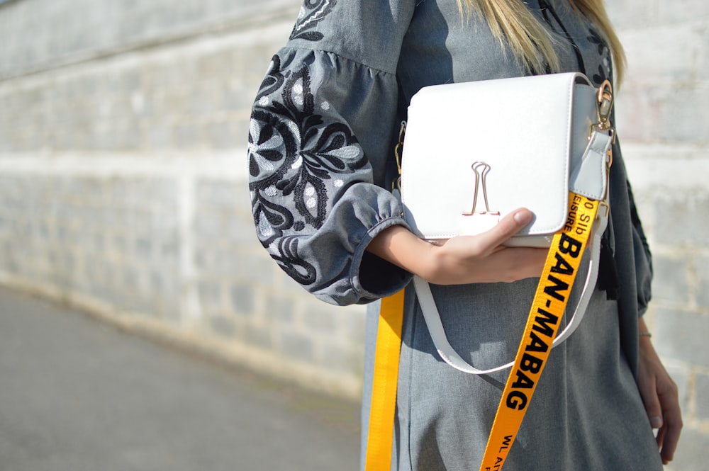 woman holding white handbag