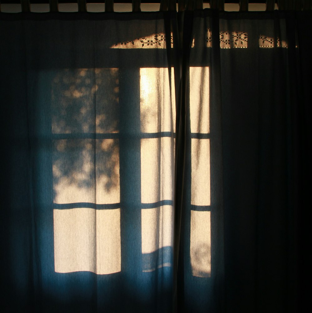 rideau bleu devant la fenêtre pendant la journée