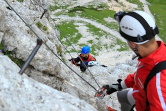 A climber wearing a helmet and gloves, preparing gear before ascent.