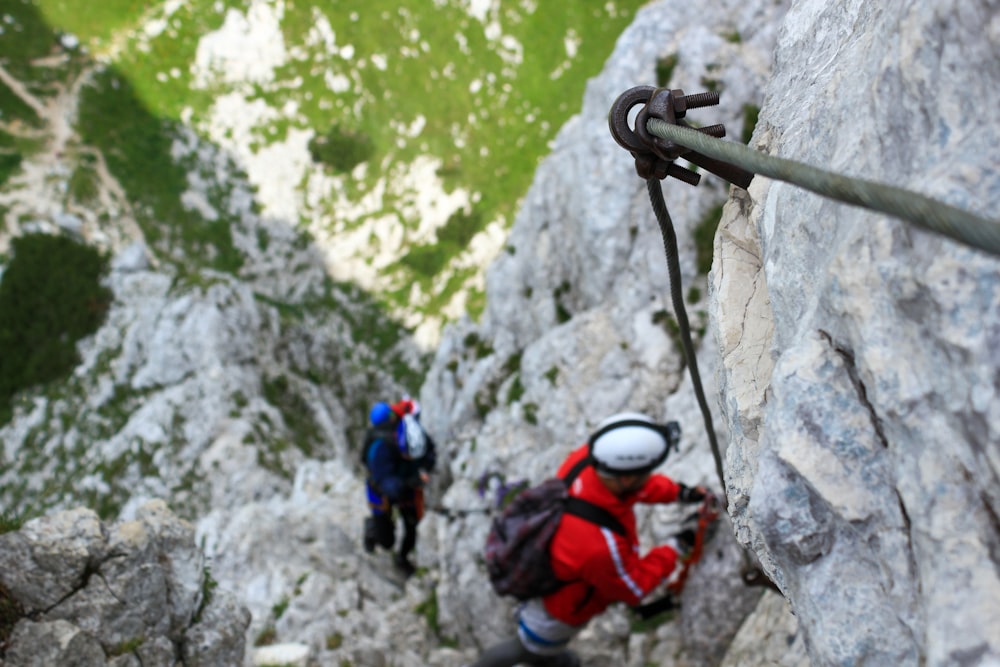 man climbing on gray mountain