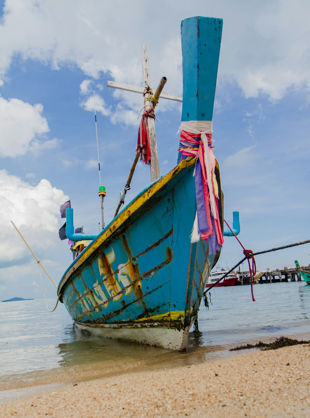 blue wooden boat on seashore during daytime