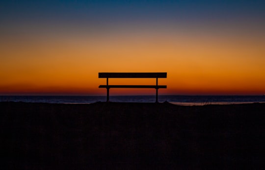 bench near shoreline during sunset in New Romney United Kingdom