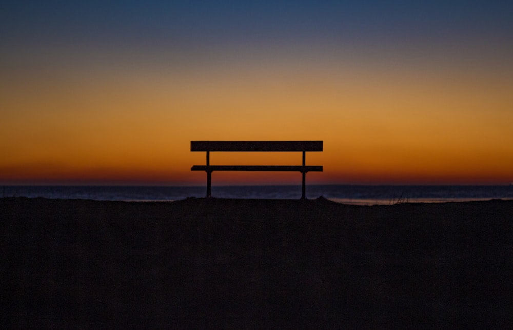 bench near shoreline during sunset