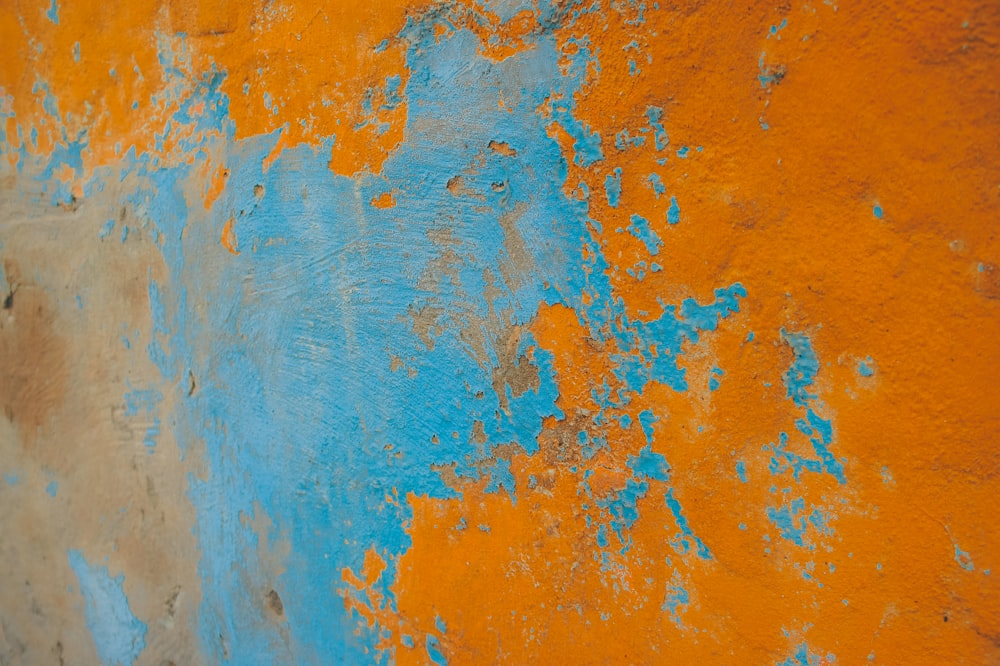 un muro arancione e blu con vernice scrostata