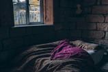 Sunlit cozy suite featuring stone walls and a comfortable bed with soft linens.