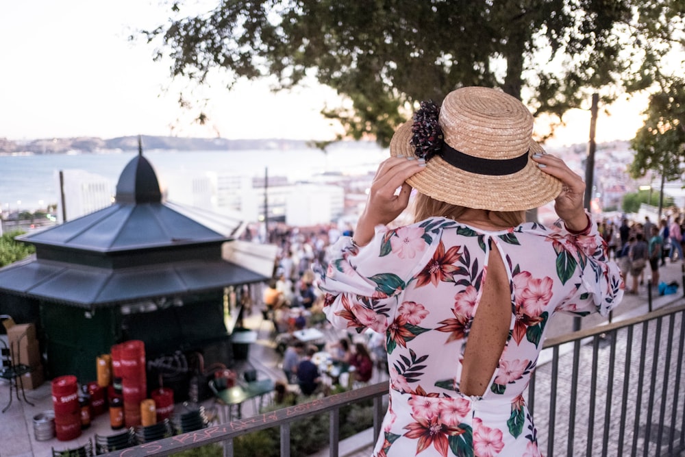 woman touching her brown sun hat during daytime