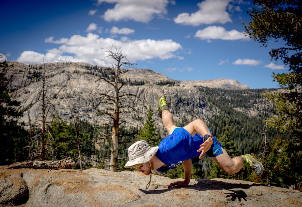 Mann macht Handstand am Rande der Klippe