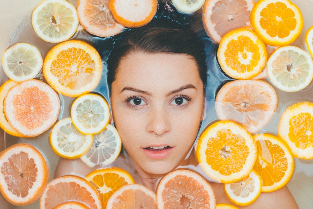 a woman surrounded by sliced lemons, for cbd skincare