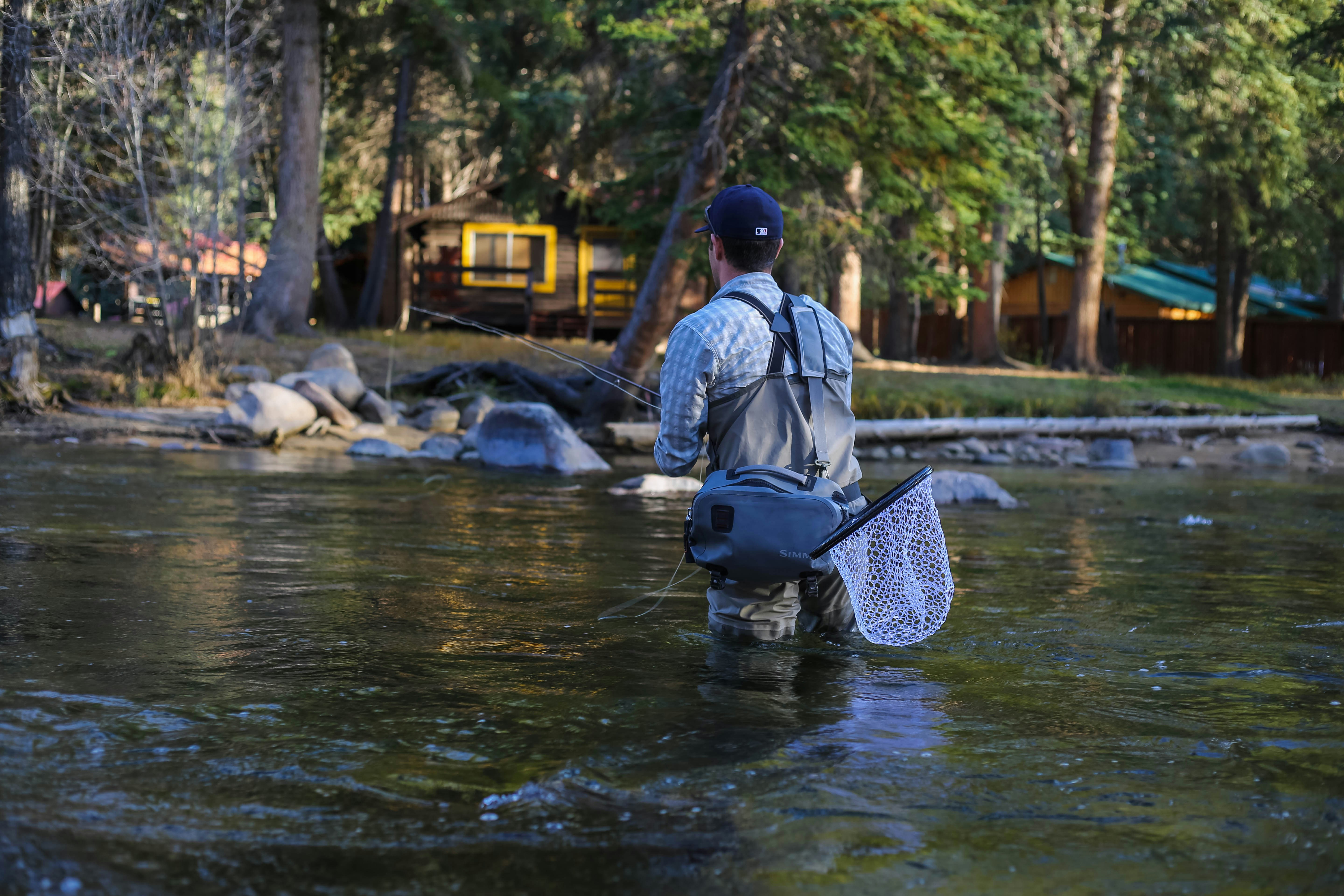 man fishing river at daytime