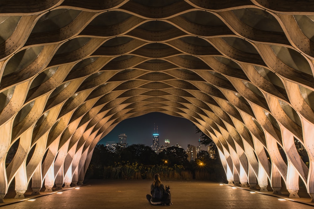 person sitting inside a brown tunnel