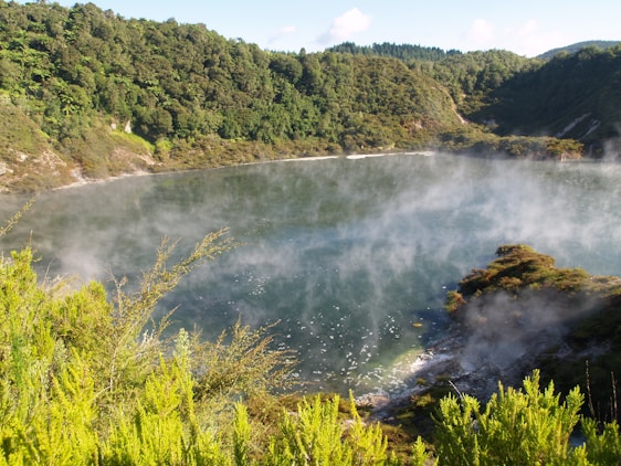 A serene lakeside sauna with steam rising gently into the crisp Nordic air at sunset.