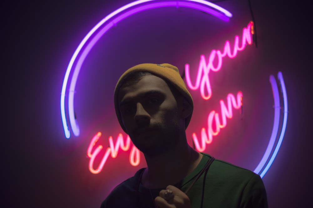 man standing in front of neon light signge