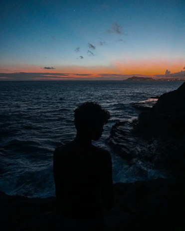 Mysterious silhouette of Joy Boy surrounded by ancient symbols and ocean waves.