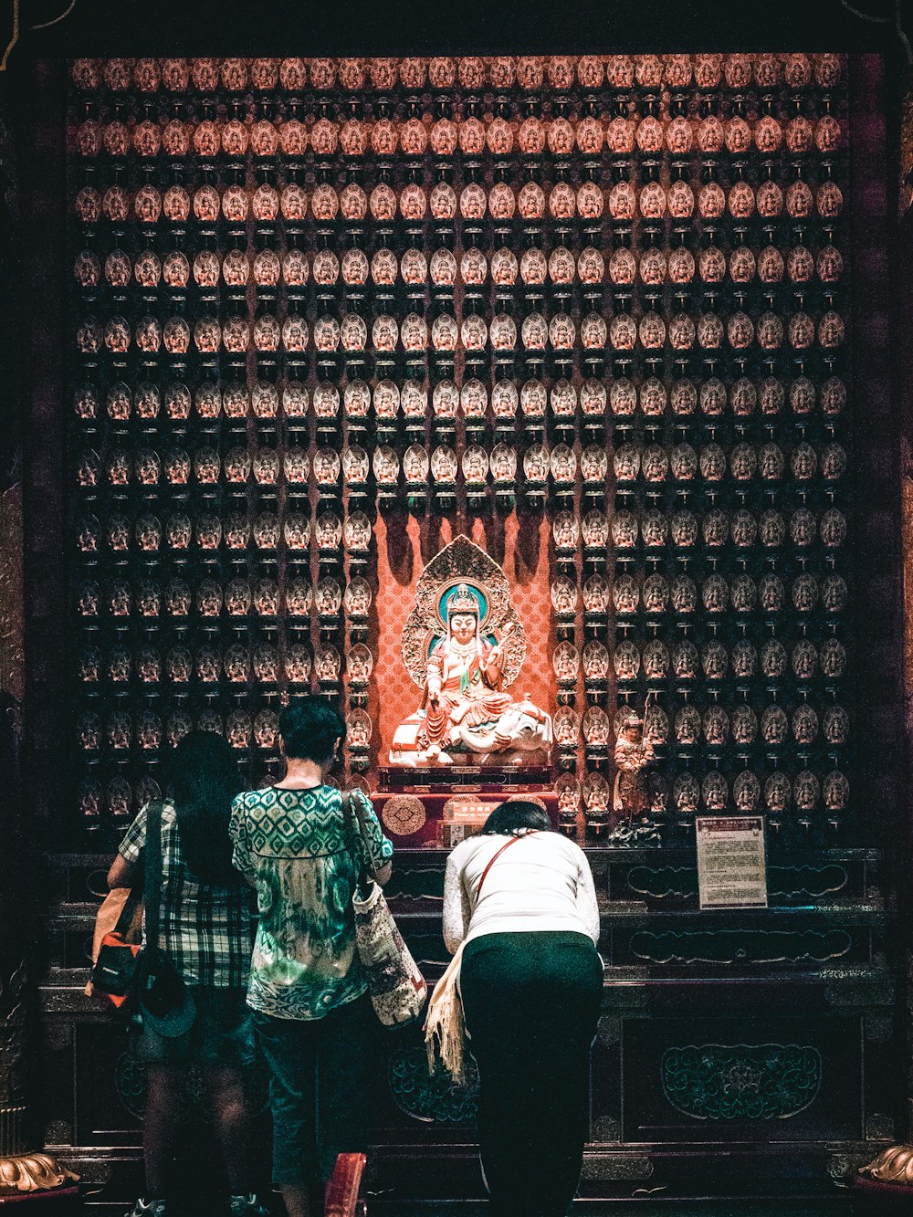 three people praying in front of altar