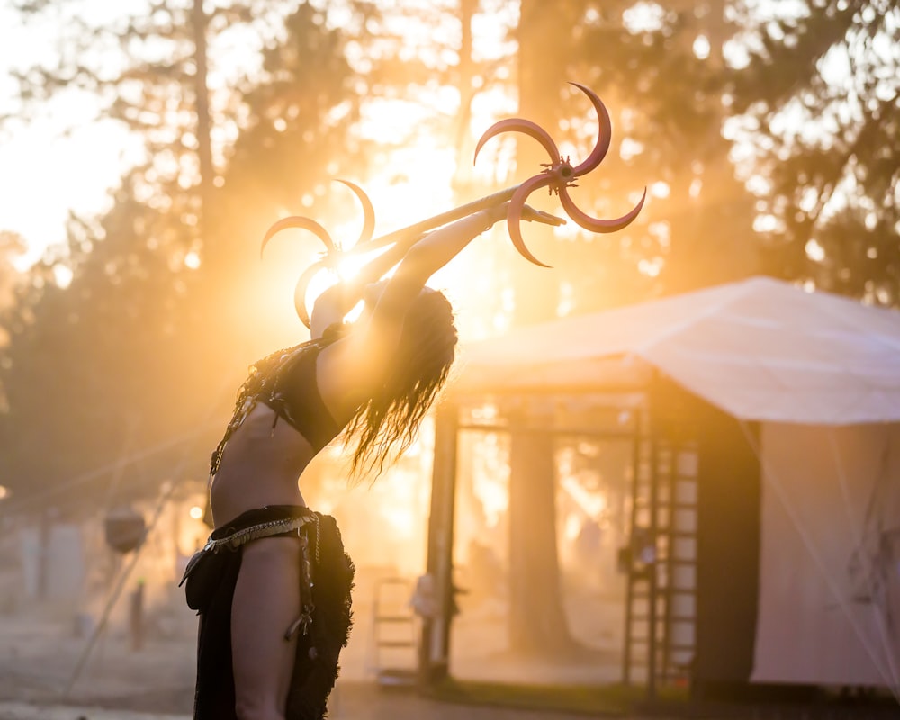 Mujer levantando la barra de metal cerca de la carpa blanca