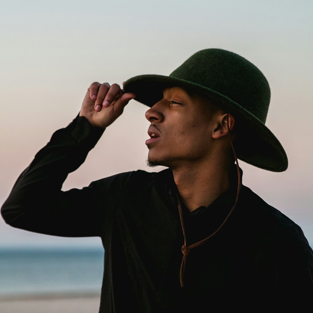 man holding his black hat